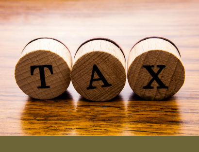 Corks spelling out tax set on a wooden table